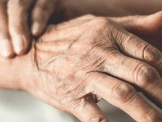 Image of an elderly person holding their wrist, in pain.