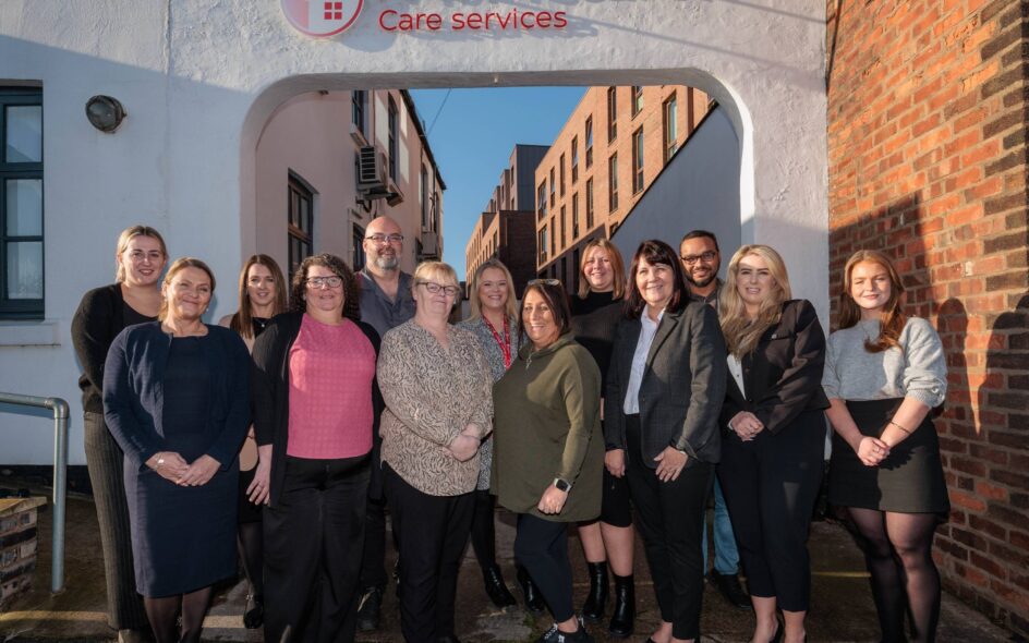 A group of people stood in front of a building with a plaque stating 'Homecarers Care Services' for blog post on the best home care provider