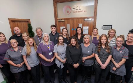 Image of a group of people in an office setting, wearing a care assistant uniform.