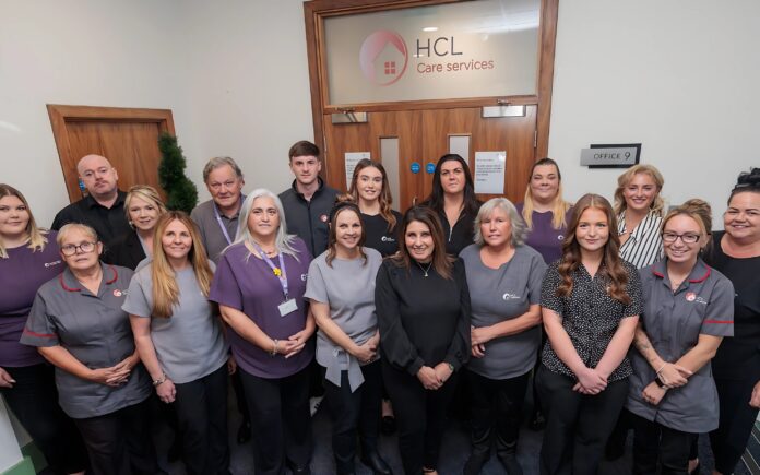 Image of a group of people in an office setting, wearing a care assistant uniform.