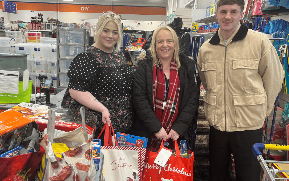 Image of 3 people with bags of toys in a large supermarket.