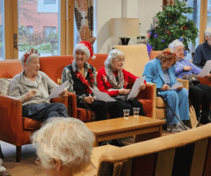 Image of service users in a care home, enjoying a Christmas party.