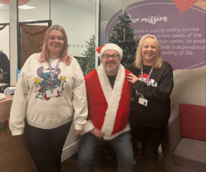 Image of 3 people in front of a Christmas tree wearing Christmas Jumpers.
