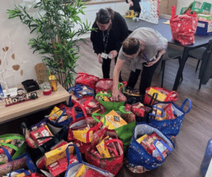 Image of an office setting, with multiple shopping bags on the floor filled with goods.