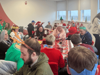 Room of people taking part in celebrations for a Christmas party.