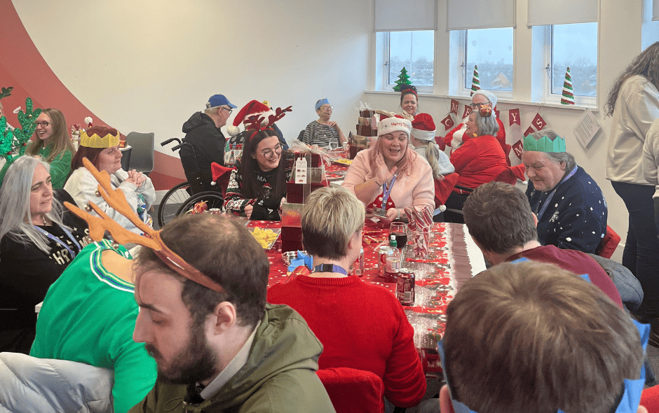 Room of people taking part in celebrations for a Christmas party.