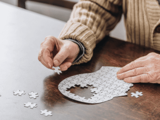 Image of a person putting together a puzzle on a table.