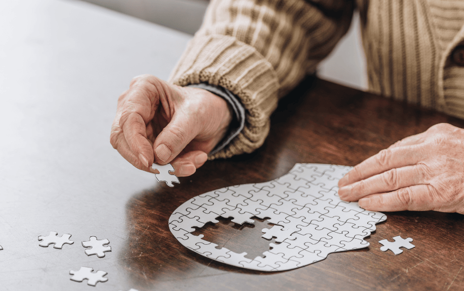 Image of a person putting together a puzzle on a table.