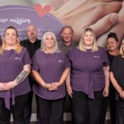 Image of a group of people in an office setting, wearing a care assistant uniform.