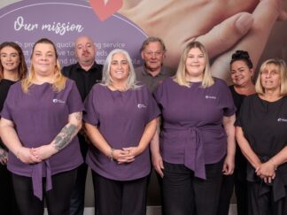 Image of a group of people in an office setting, wearing a care assistant uniform.